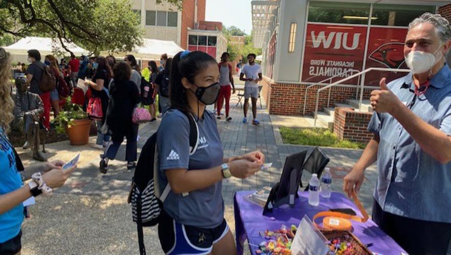 Students at a hand out table in the UIW quad