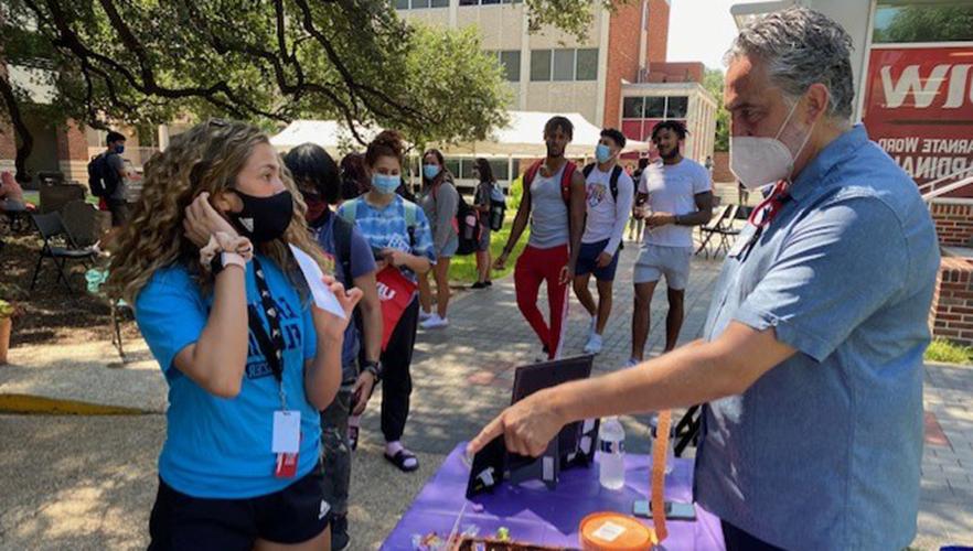 Students at a hand out table in the UIW quad