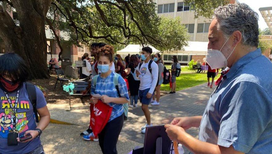 Students at a hand out table in the UIW quad